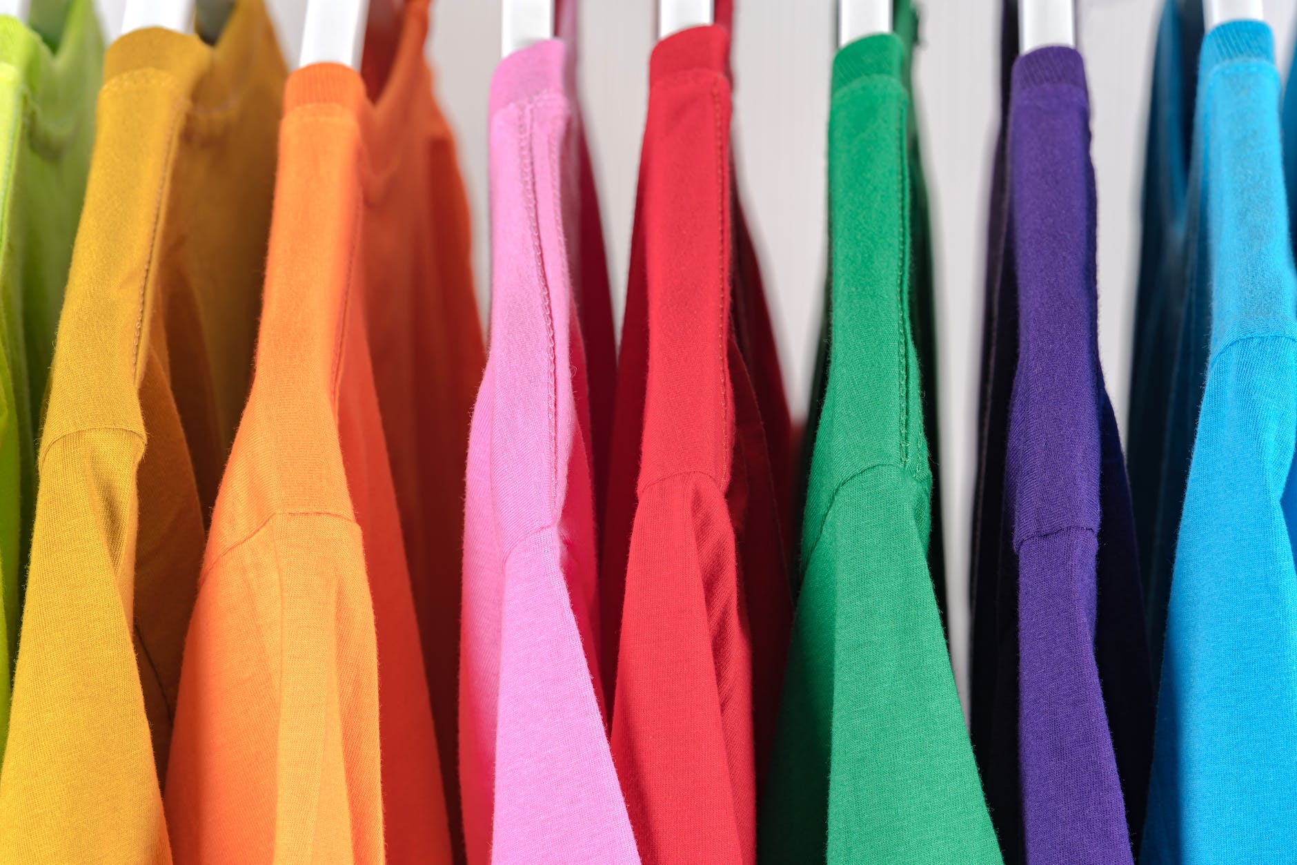 collection of colorful cotton t shirts on hangers in store